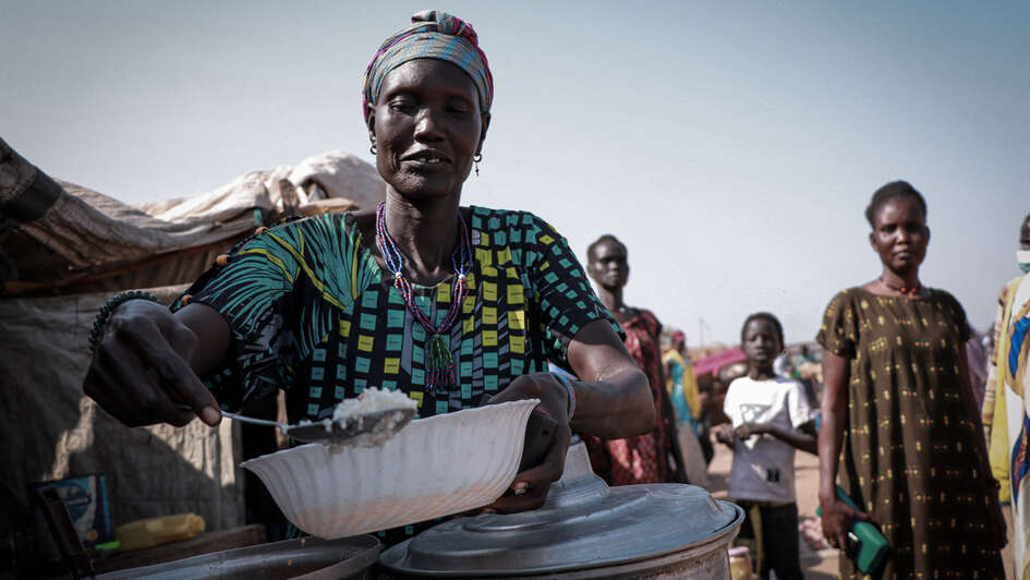 Eine Frau füllt eine Schüssel mit Reis.