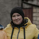 Eine Mutter und ihre beiden Kinder lächeln in die Kamera für eine Profilaufnahme