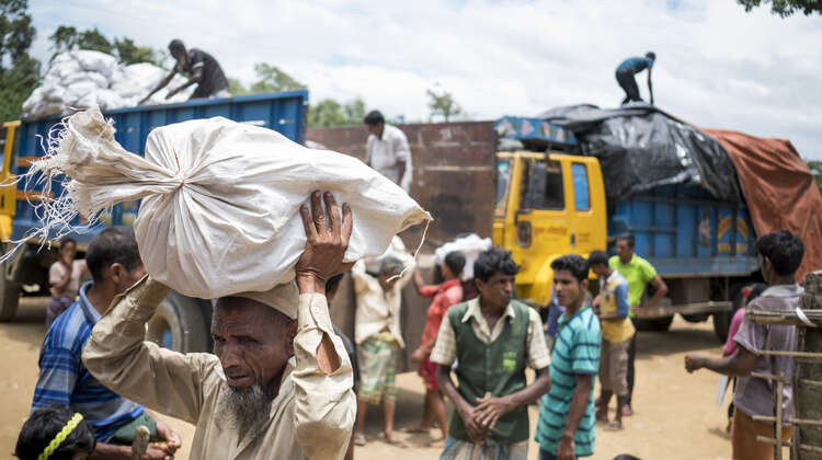 Ein Mann trägt einen Sack mit Brennmaterial im Camp Hakimpara, Bangladesch, August 2018.