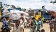 Ein Mann trägt einen Sack mit Brennmaterial im Camp Hakimpara, Bangladesch, August 2018.