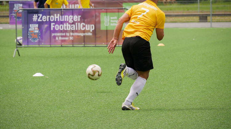 Ein Fußballspieler dribbelt den Ball beim #ZeroHunger-FootballCup 2018 in Bonn.