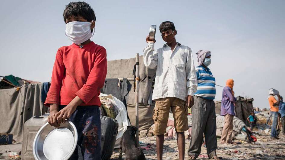 Klimawandel und Corona: Auswirkungen in Ländern des Globalen Südens sind dramatisch. Bild: Mehere Menschen stehen in einer Schlange.