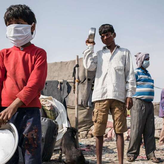 Klimawandel und Corona: Auswirkungen in Ländern des Globalen Südens sind dramatisch. Bild: Mehere Menschen stehen in einer Schlange.