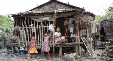Zin Mar Htwe mit ihrer Familie vor ihrem zusammengeschusterten Haus