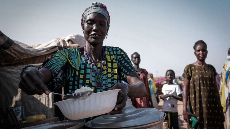 Eine Frau füllt eine Schüssel mit Reis