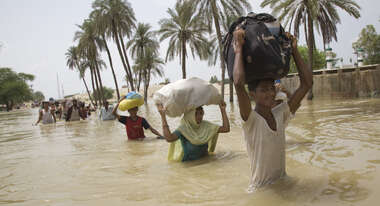 Überschwemmung in Pakistan: Familien kämpfen sich durch die Wassermassen.