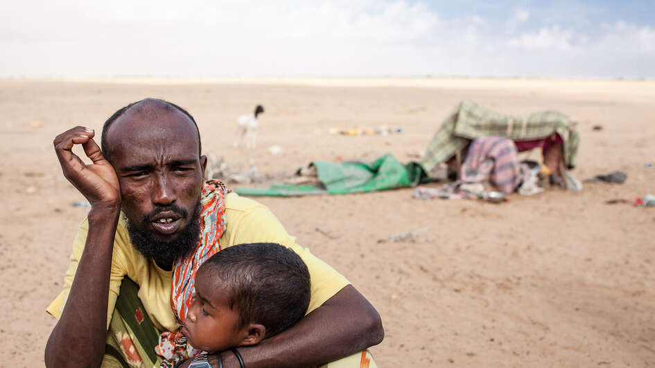 Ein erschöpfter Vater mit seinem Kind in Somaliland