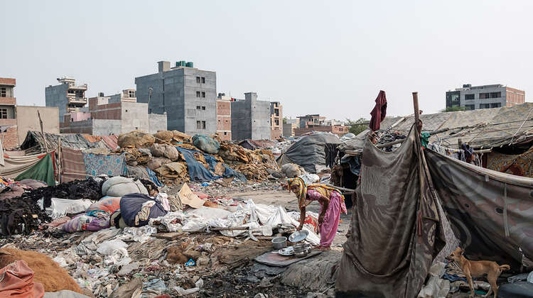 2020-coronavirus-freu-slum-delhi-klimawandel-indien-c-florian-lang.jpg Eine Frau hebt Töpfe vom Boden auf. Um sie heraum sieht man Zeltplanen, Unrat und Müll.