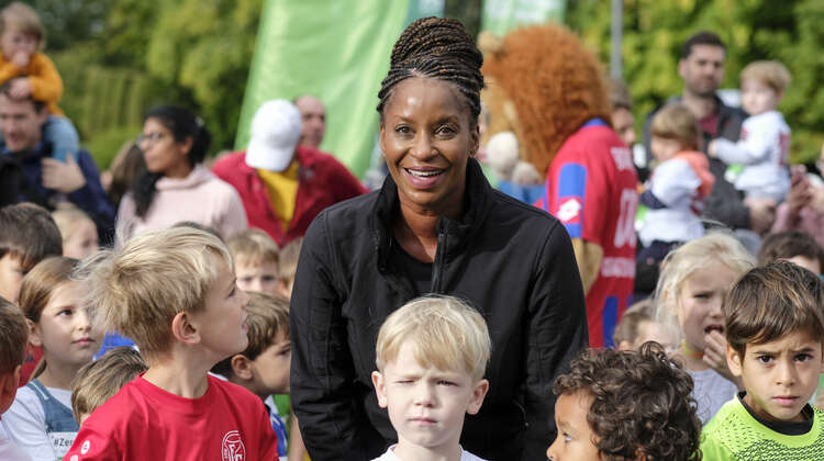 Liz Baffoe posiert mit teilnehmenden Kindern für die Kamera.