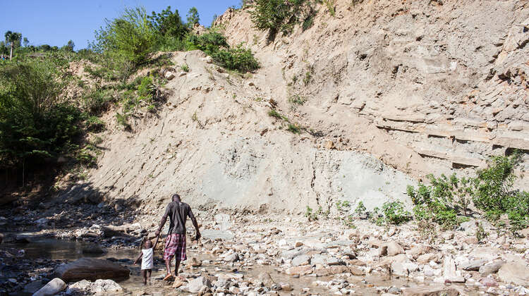 2016-klimawandel-haiti-steinbruch-duerre-welthungerhilfe.jpg Ein Vater geht mit seinem Kind durch einen Steinbruch.