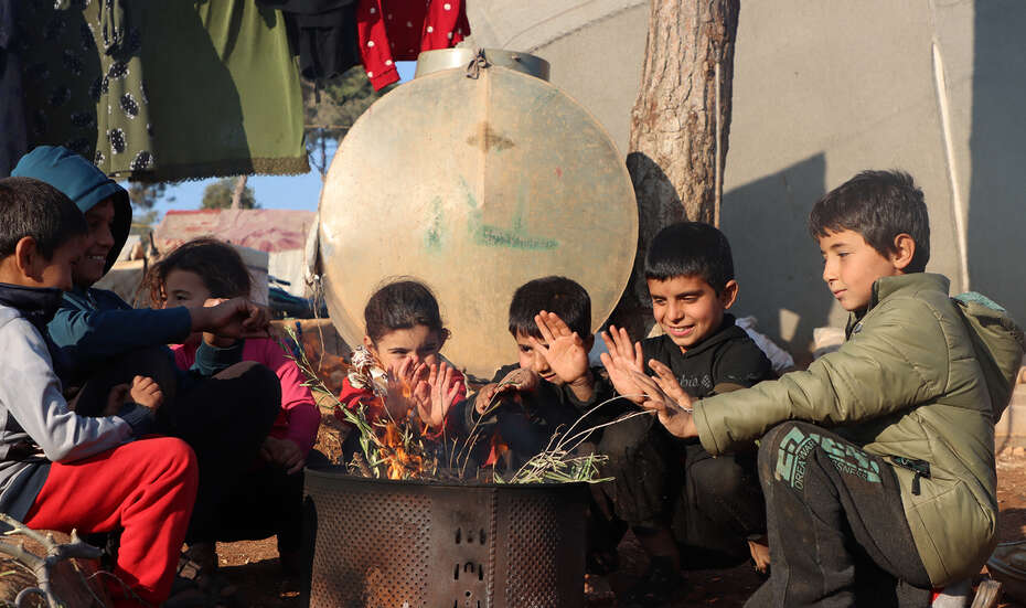 Syrien im Winter: Mehrere Kinder sitzen vor einer Feuertonne.