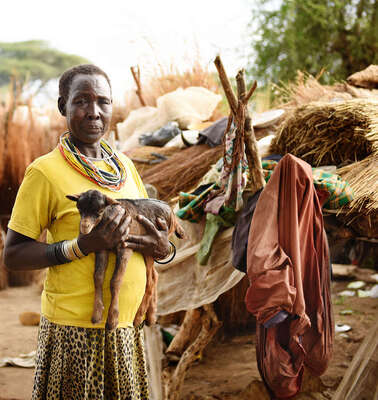 Eine Frau hält eine Ziege auf dem Arm in Moroto, Uganda.
