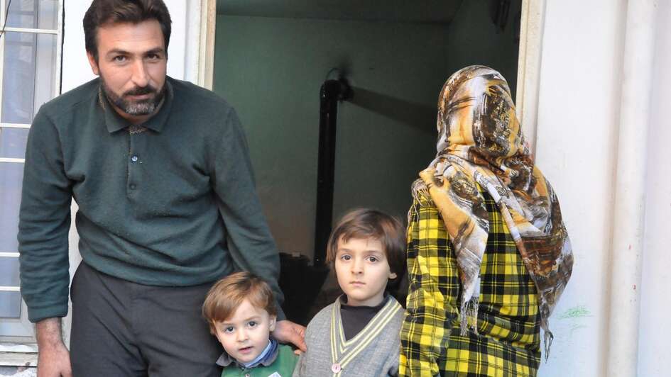 Afafe und Khaled mit ihren Kindern vor einem Haus