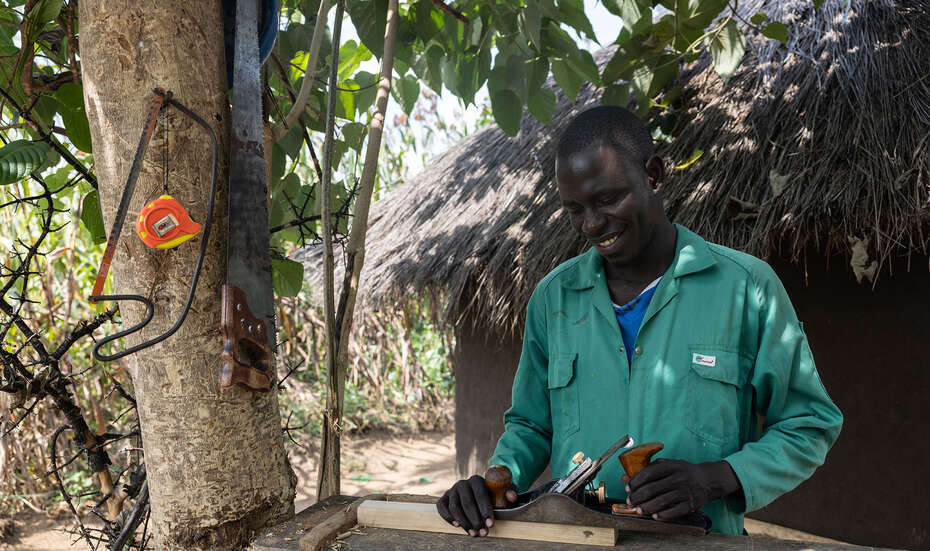 Ein Schreiner bearbeitet ein Stück Holz