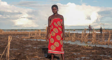 Eine Frau steht auf einem zerstörten Maisfeld.