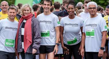 Fünf Menschen schauen lächelnd in die Kamera.