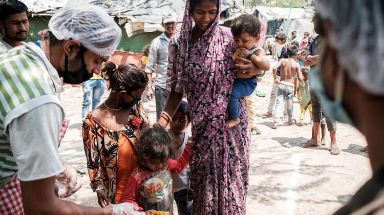 2020-coronavirus-slum-essensausgabe-frau-kinder-delhi-indien-c-florian-lang.jpg Eine Frau mit drei Kindern bei der Essensausgabe.