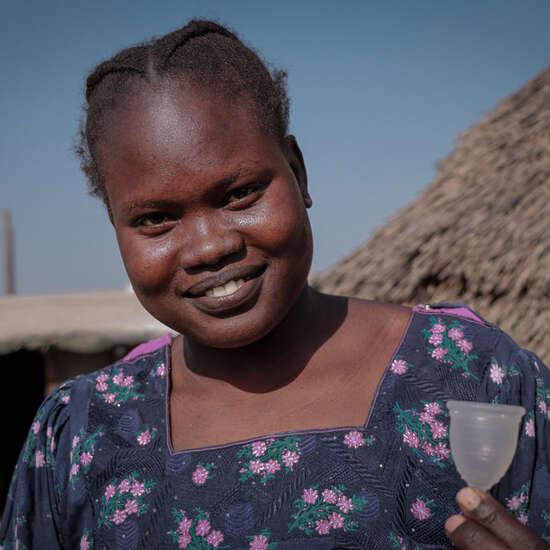 Eine junge Frau zeigt eine Menstruationstasse, Bentiu, Unity State, Südsudan Januar 2022. 