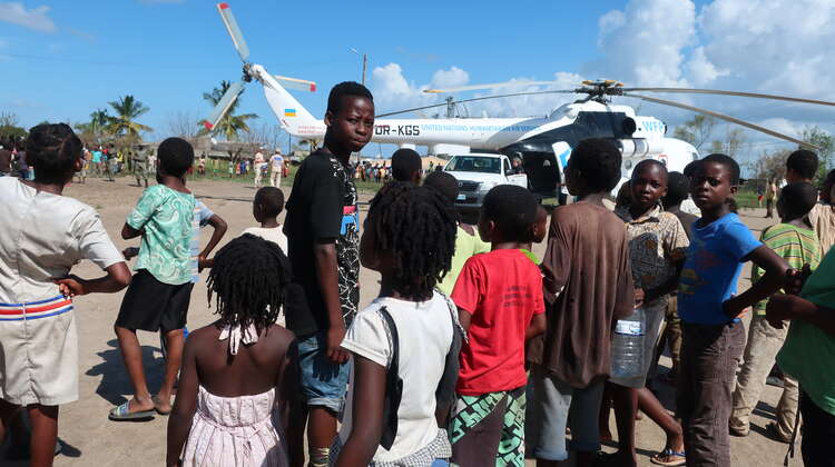 2019-4-Wochen-nach-zyklon-idai-Hilfslieferung-Mozambique-Nhamatanda-Bandsom-welthungerhilfe.JPG Kinder und Jugendliche stehen erwartungsvoll vor einem großen Helikopter.