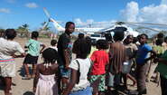 2019-4-Wochen-nach-zyklon-idai-Hilfslieferung-Mozambique-Nhamatanda-Bandsom-welthungerhilfe.JPG Kinder und Jugendliche stehen erwartungsvoll vor einem großen Helikopter.