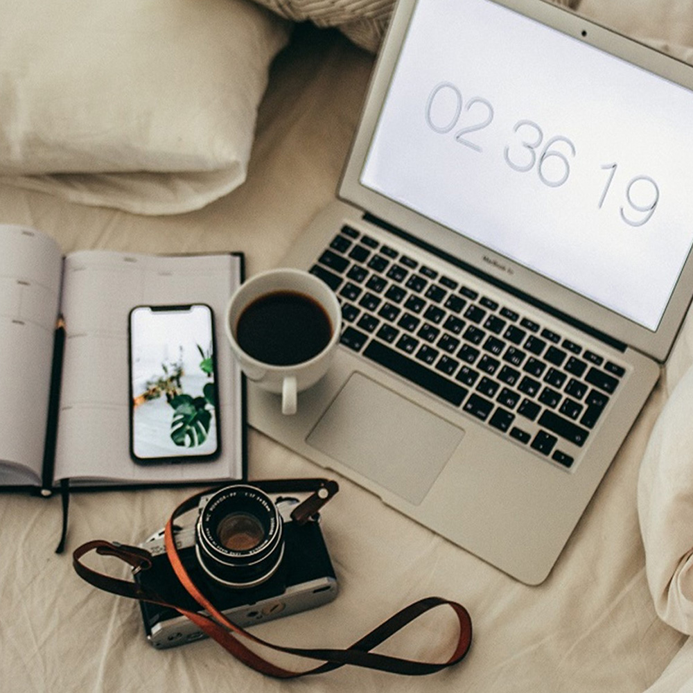 Büroutensilien: Timer, Smartphone, Kamera, Laptop, Kaffeetasse