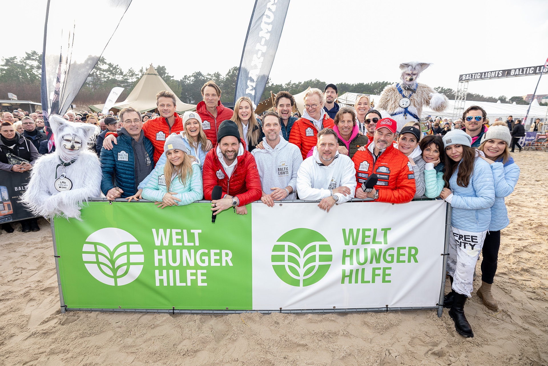 Gruppenfoto prominenter Teilnehmer*innen am Baltic Lights 2024 vor einem Banner der Welthungerhilfe