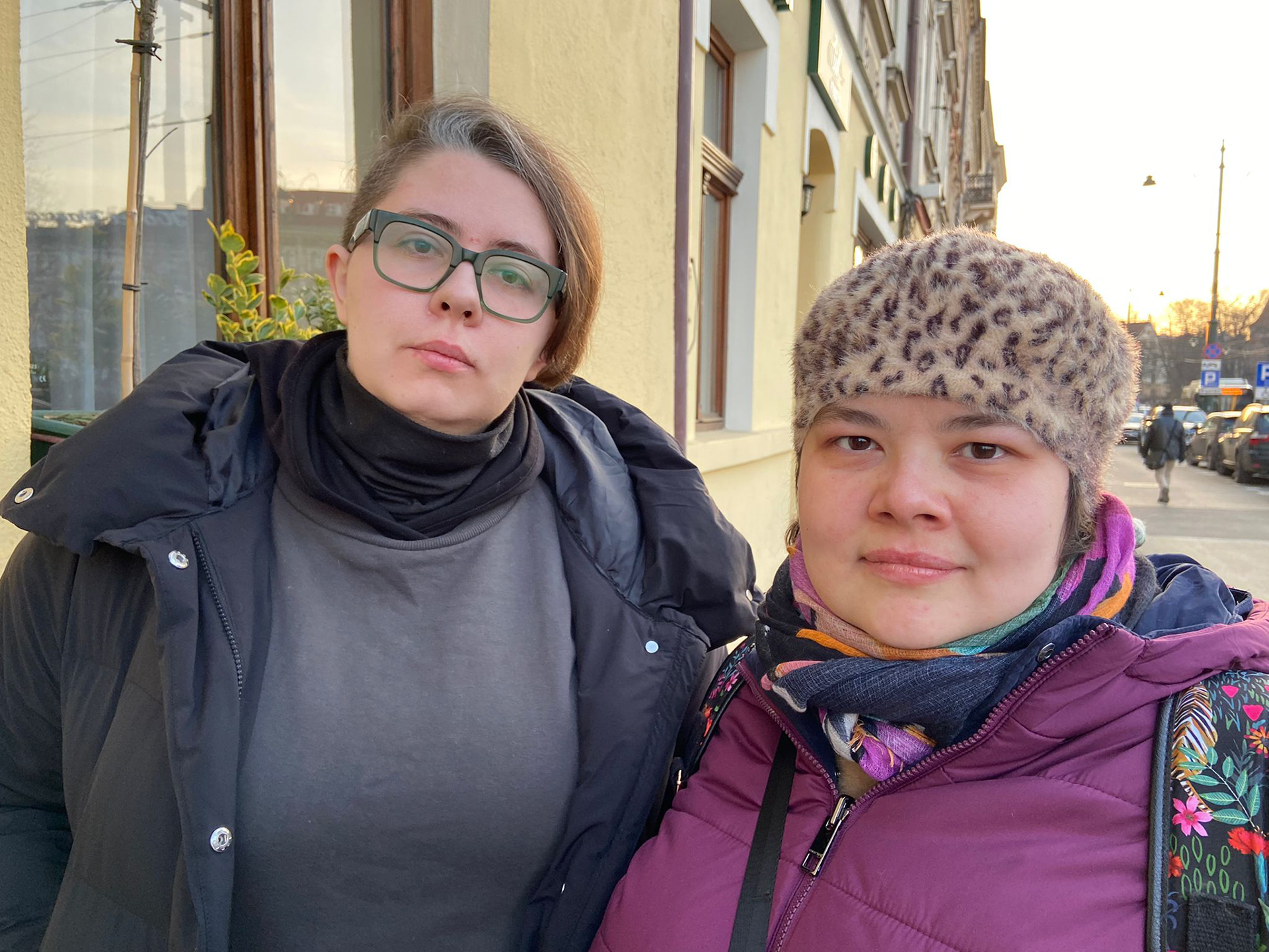 Zwei Frauen aus der Ukraine in warmer Kleidung stehen nebeneinander auf einem Gehweg, Polen 2022.