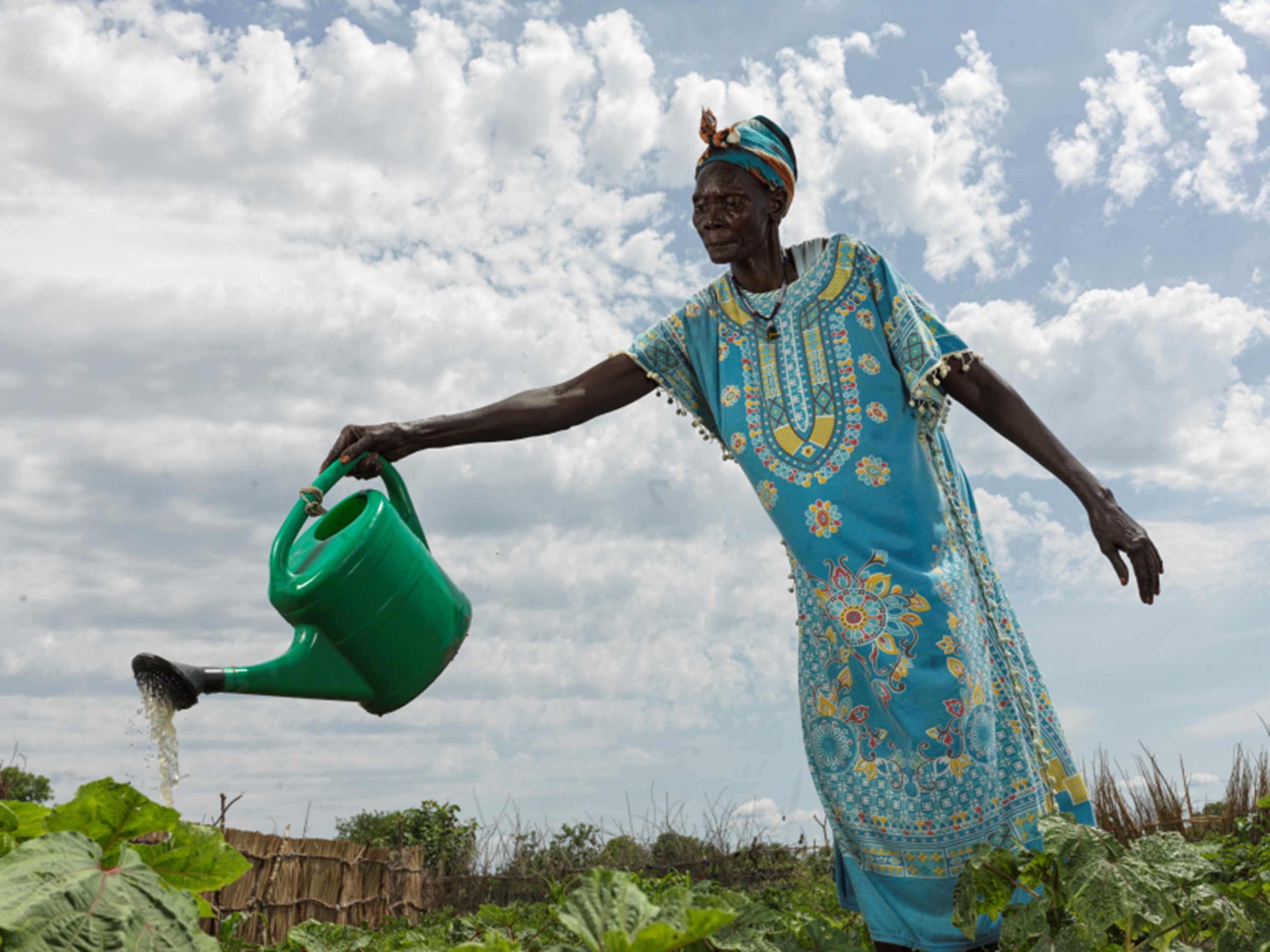 Eine Frau bewässert das Obst und Gemüse in dem schuleigenen Garten, Südsudan 2022.