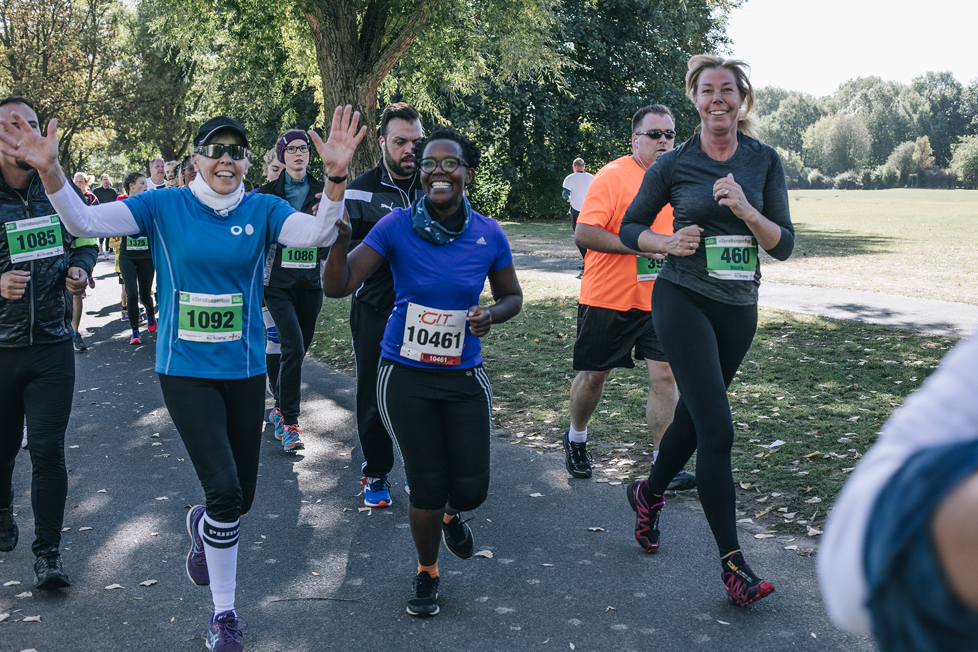Mehrere Laufende lächeln und winken, Bonn 2019. 