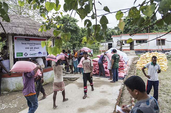 Menschen tragen Nahrugsmittel-Säcke
