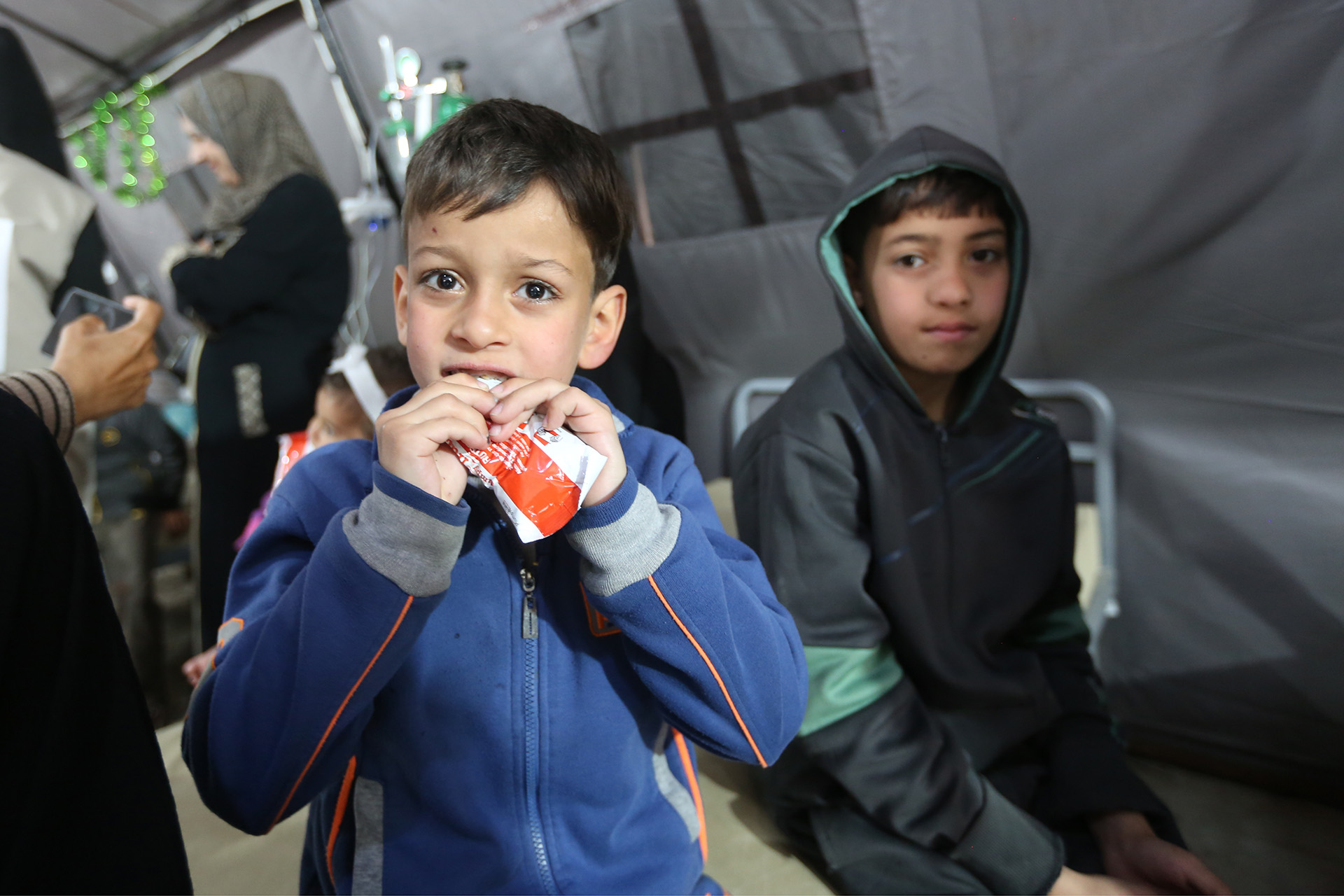 Kinder in Gaza bekommen und essen Spezialnahrung im Rahmen einer Nothilfeaktion