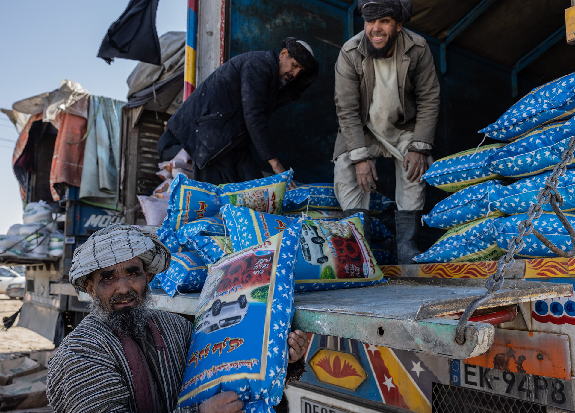 Drei Männer laden einen Lastwagen aus.
