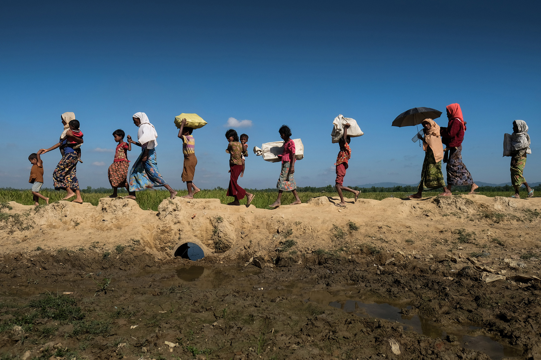 Frauen mit Kinder gehen in einer Reihe.