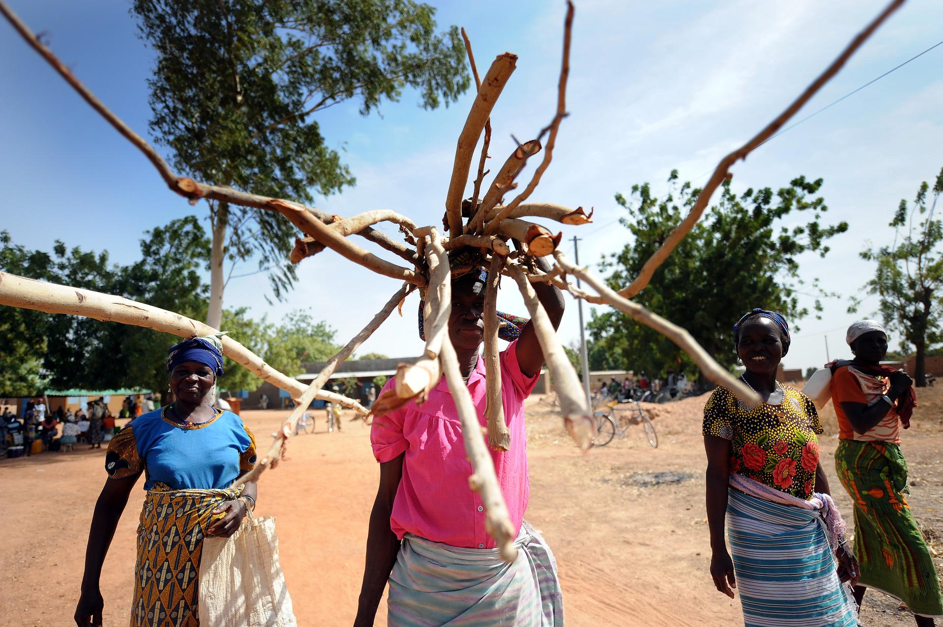 Frauen und Männer transportieren Holz in Dissin, Burkina Faso