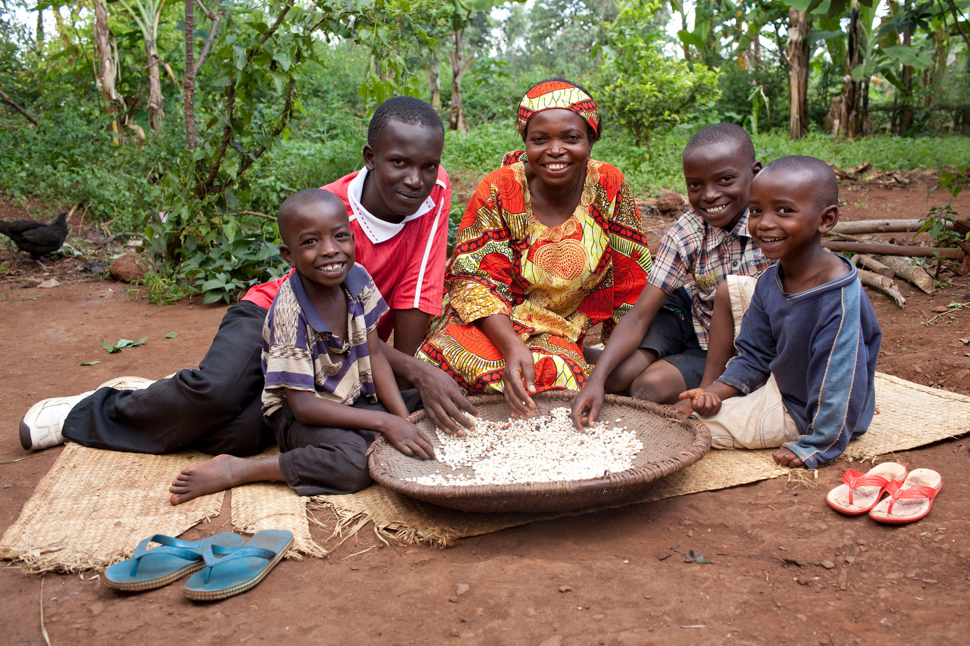 Mutter und ihre vier Kinder sitzen um eine Schüssel und lächeln für das Foto.