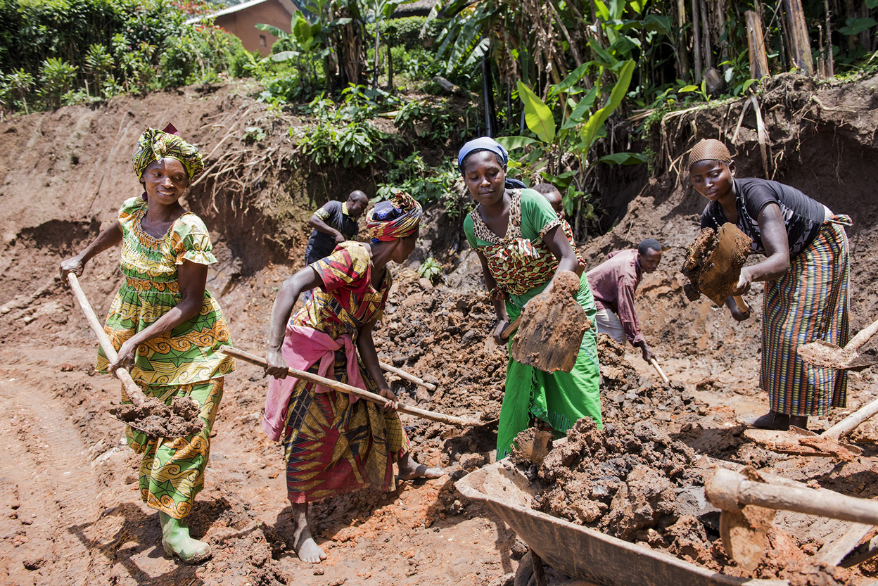Frauen mit Schaufeln in der Hand.