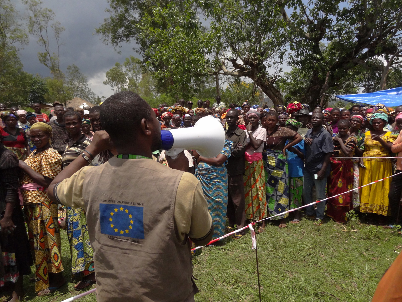 Ein Mann spricht durch ein Megaphon zu einer Menschenmenge in Katoto, Kongo