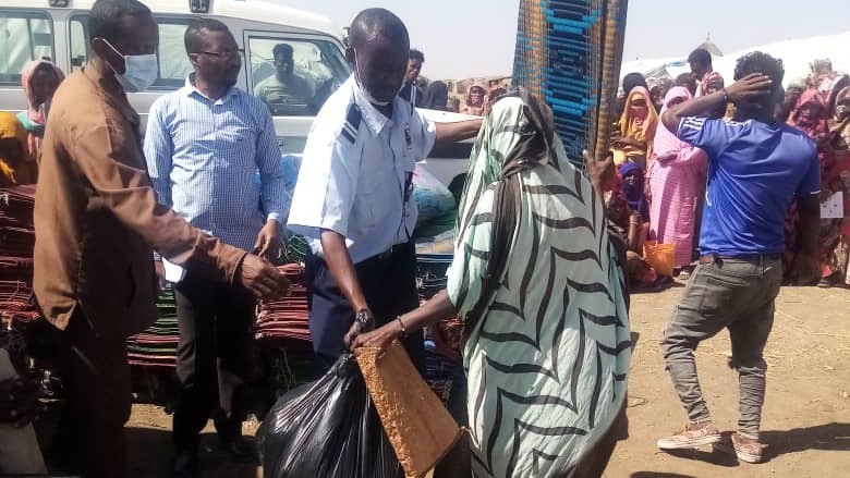 Männer und Frauen mit Nothilfe-Paketen