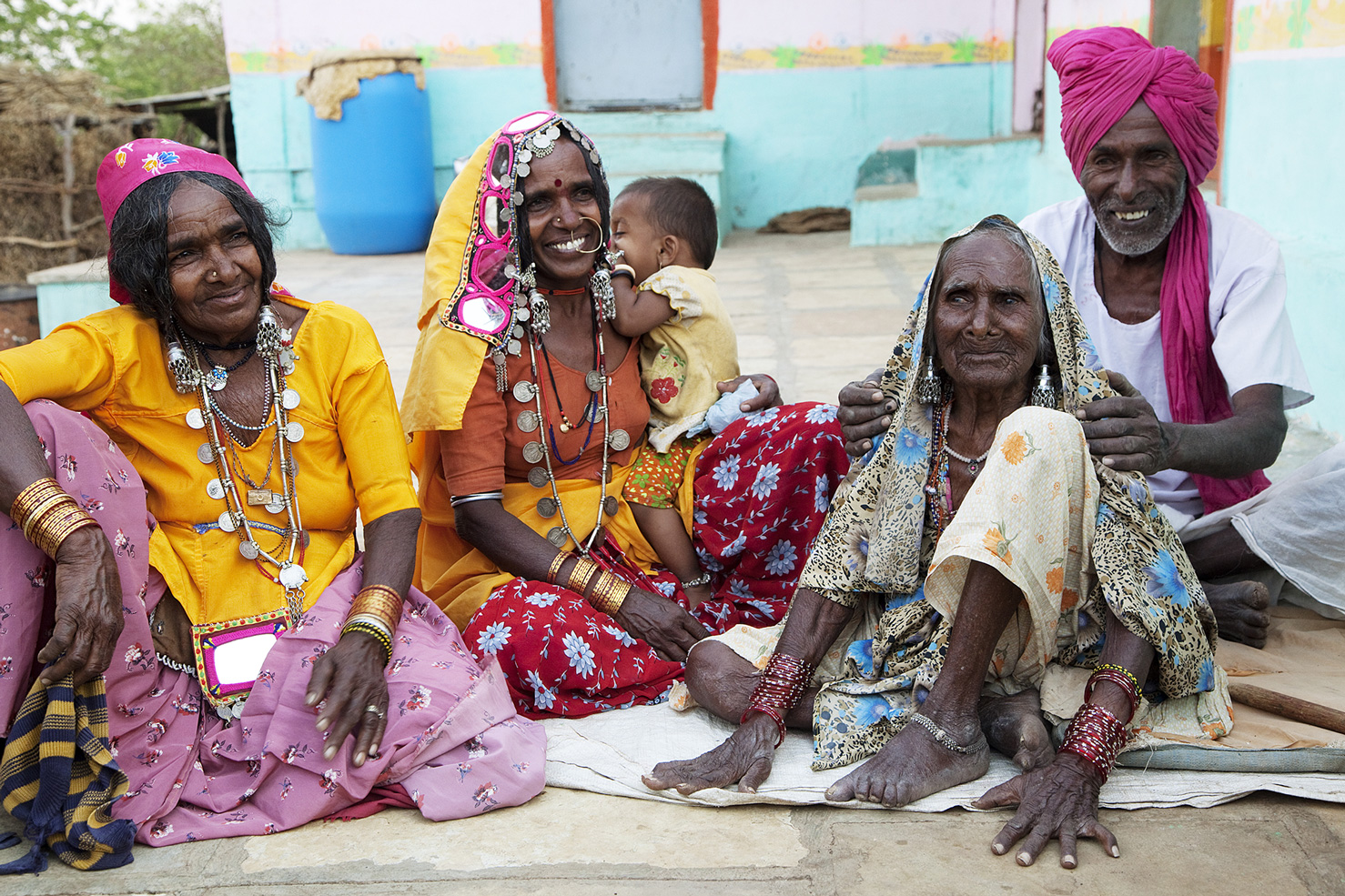 ältere Frauen in bunten Kleidern sitzen auf dem Boden