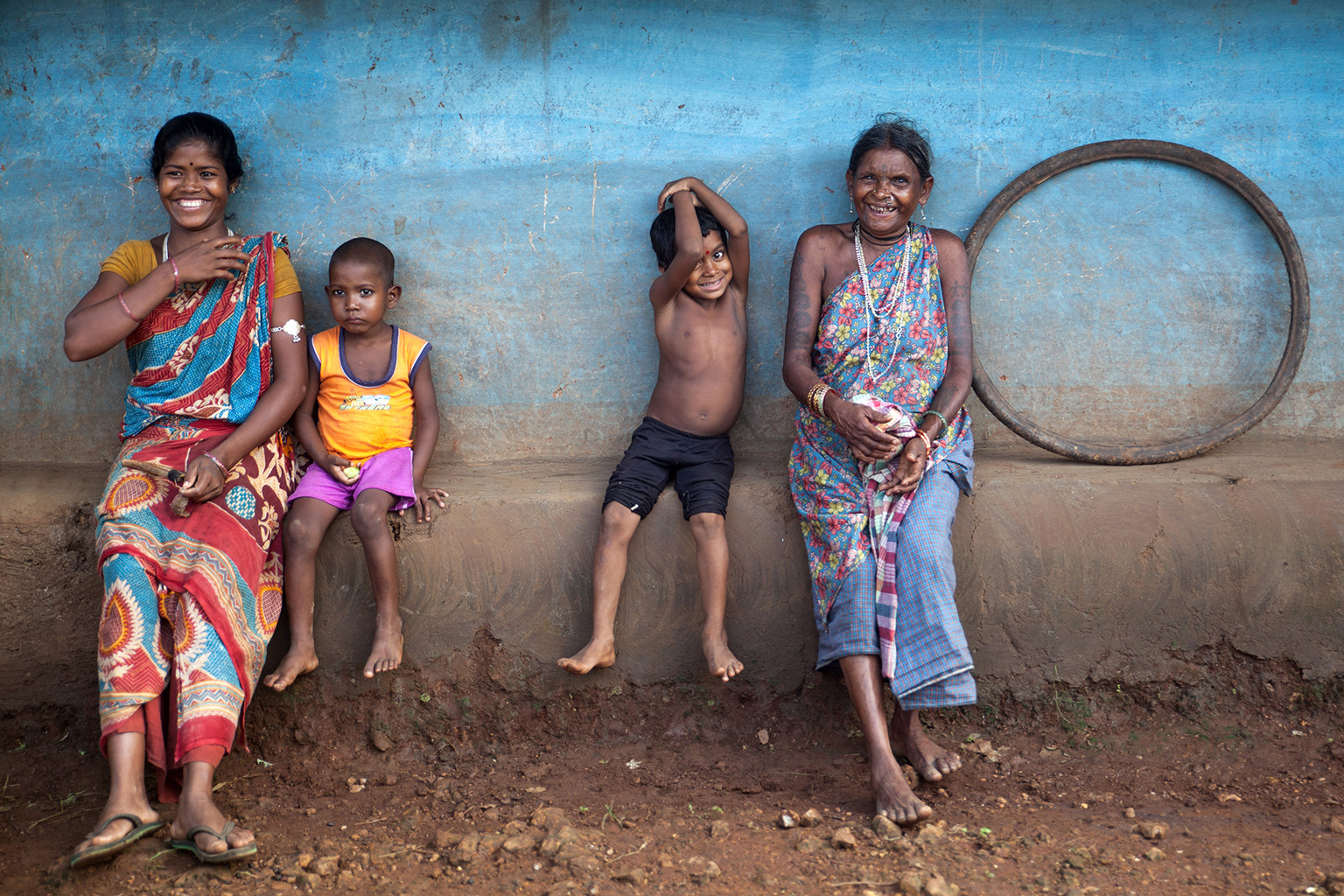 Zwei Mütter mit Kindern sitzen auf einer Bank