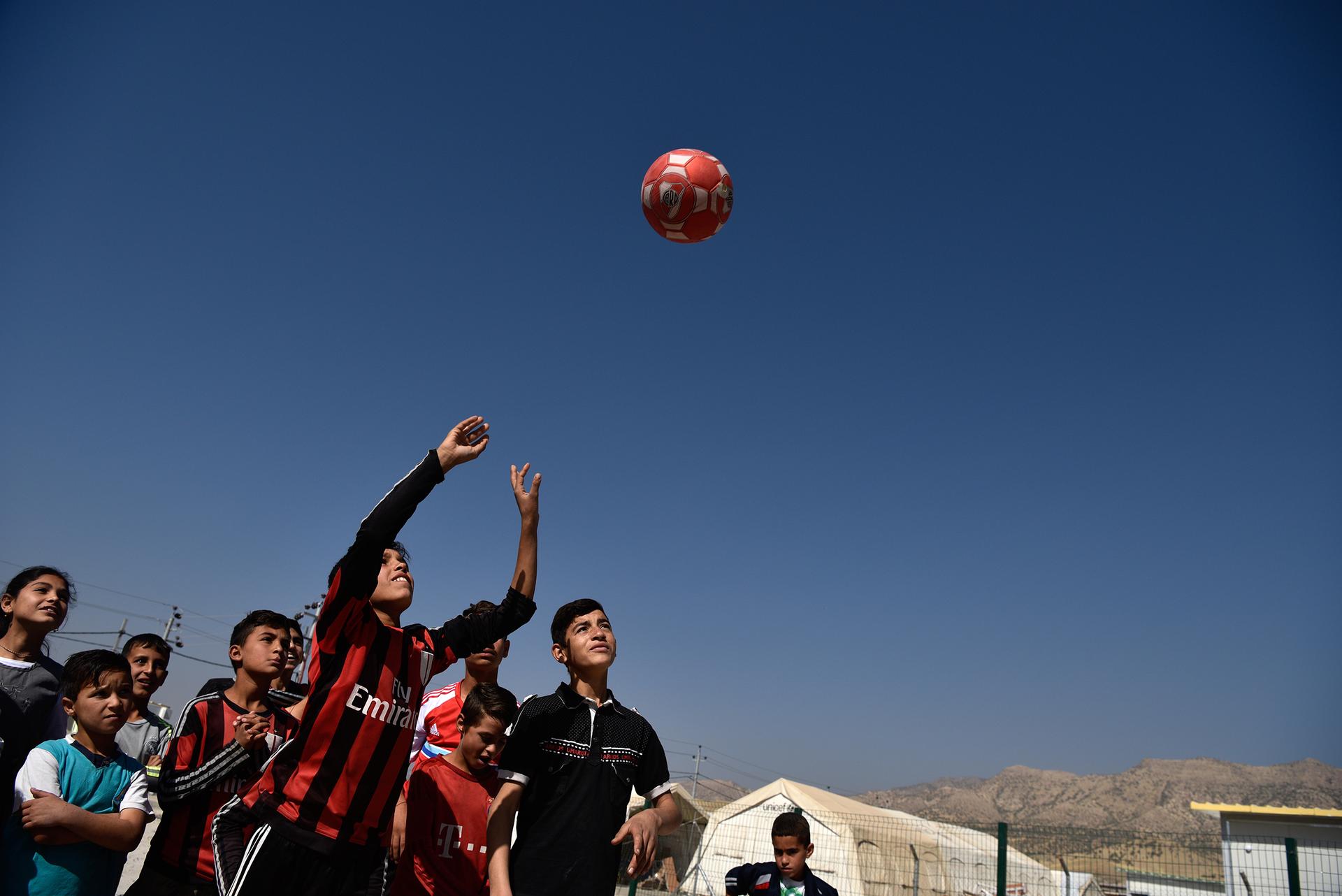 Jesidische Kinder werfen Ball in die Luft