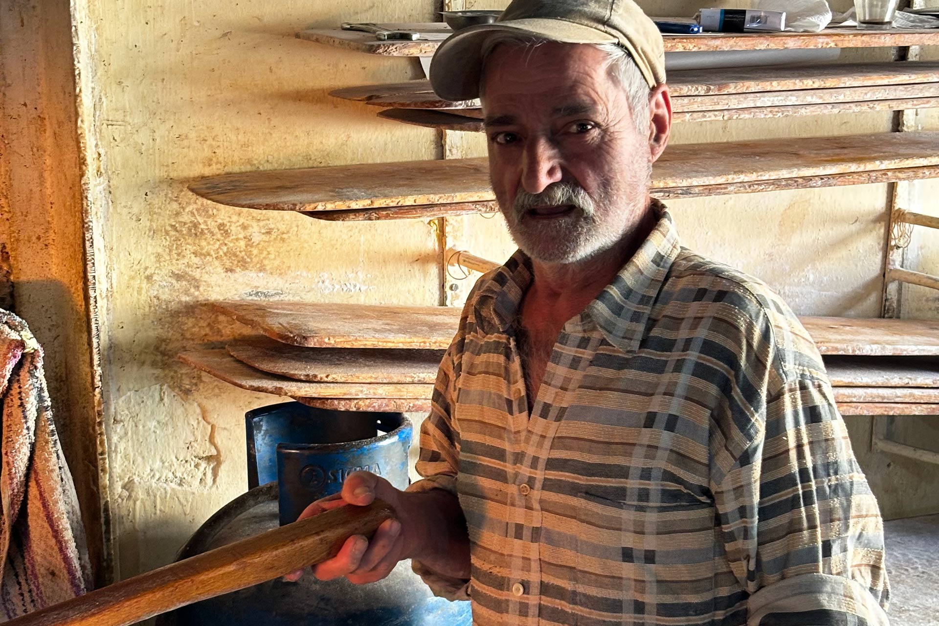 Ein älterer Mann steht in einem Raum, im Hintergrund sieht man leere Regale.