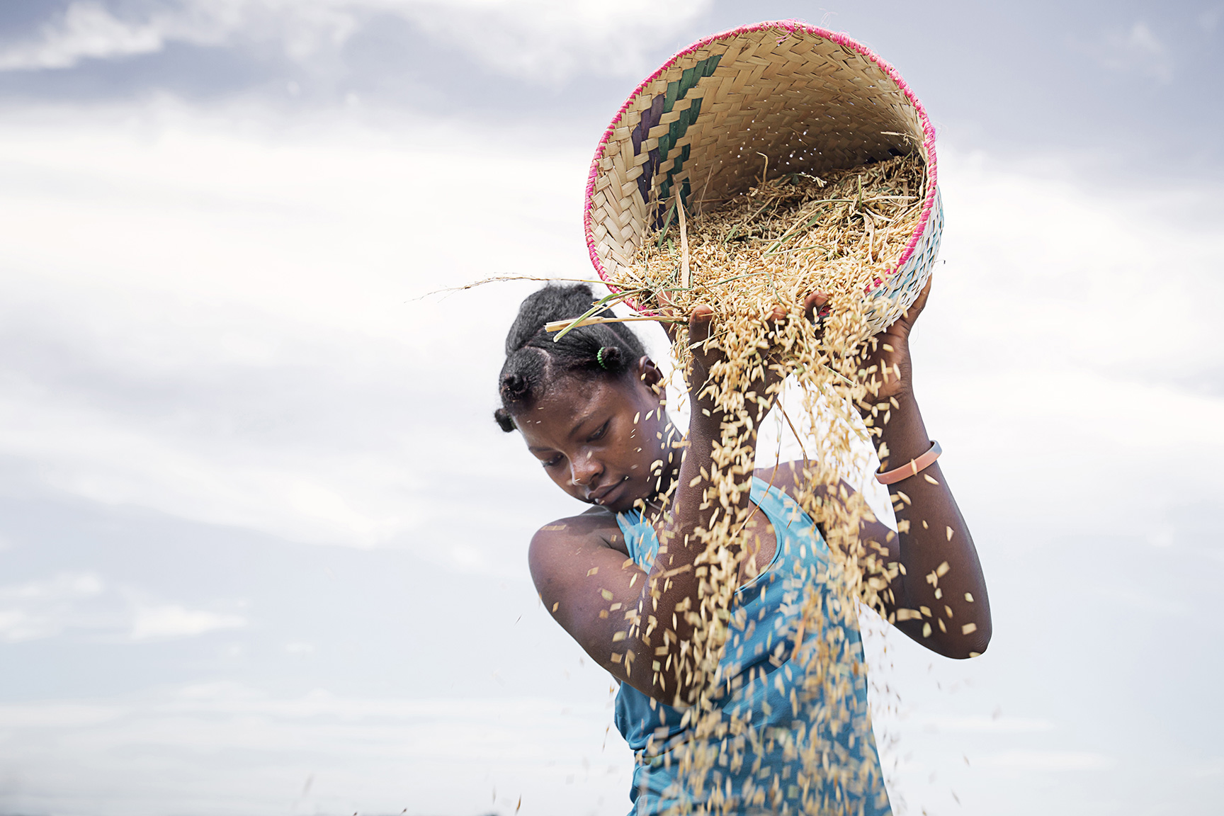 Frau schüttet einen Korb Reis aus