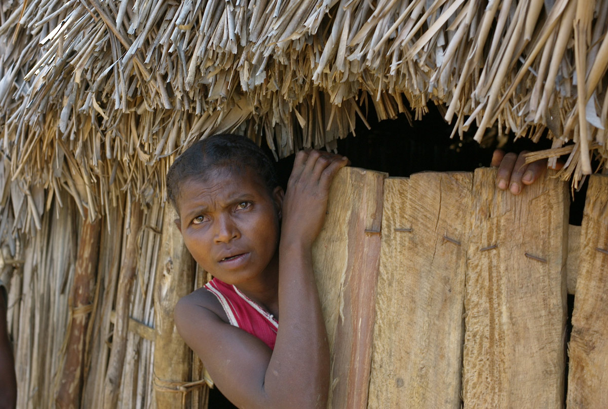 Eine Frau schaut aus ihrer Hütte in Madagaskar.