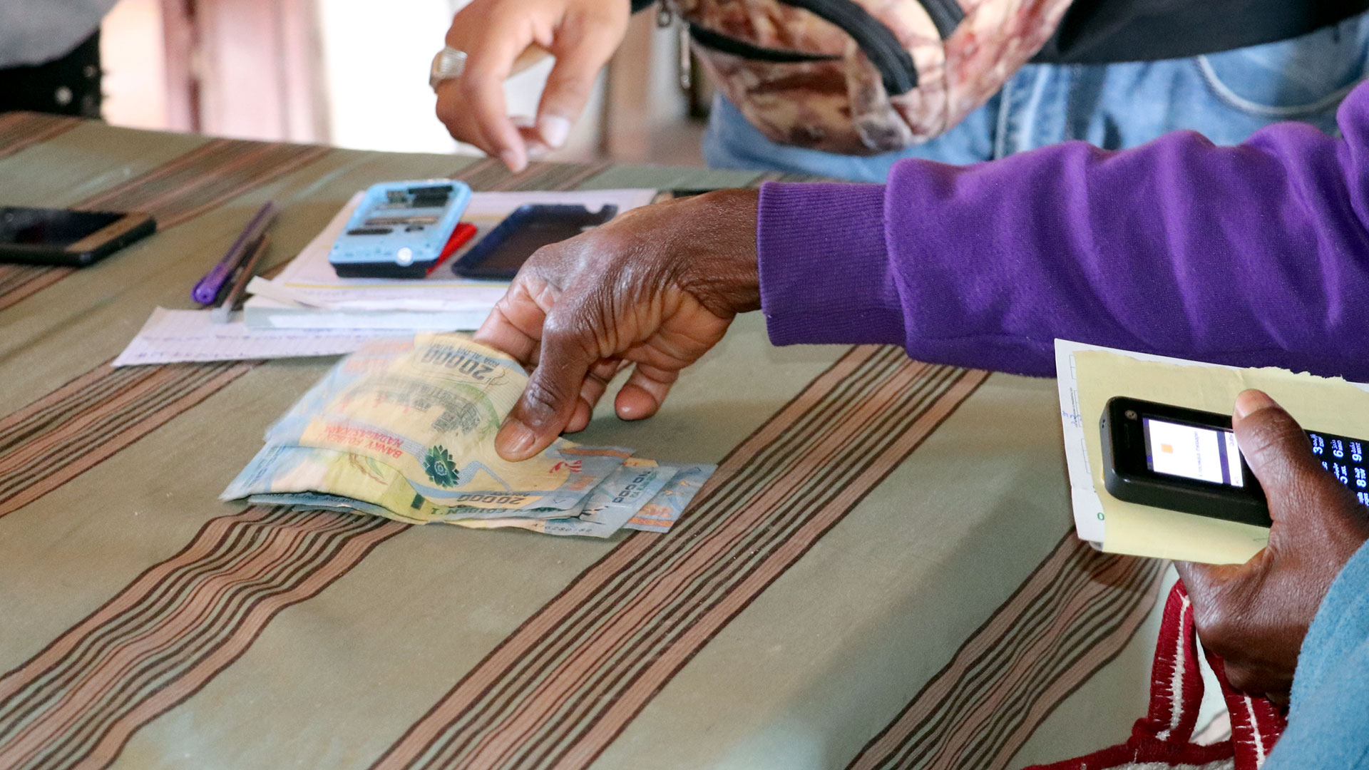 Bargeldauszahlung im Rahmen eines Welthungerhilfe-Projekts in Madagaskar. Zu sehen ist eine Hand, die Geldscheine hält.