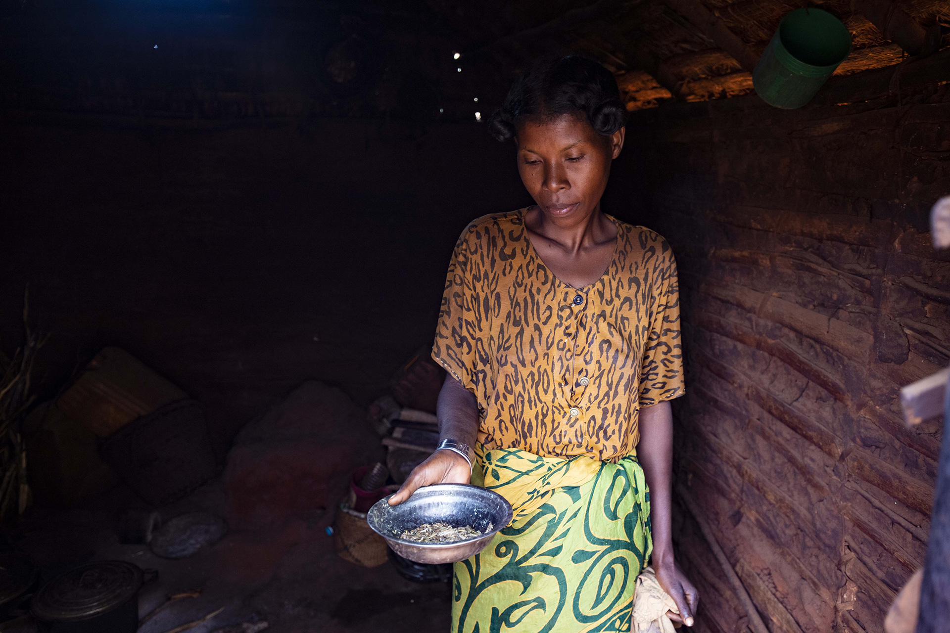 Eine Frau zeigt eine fast leere Metallschüssel, Madagaskar 2021.