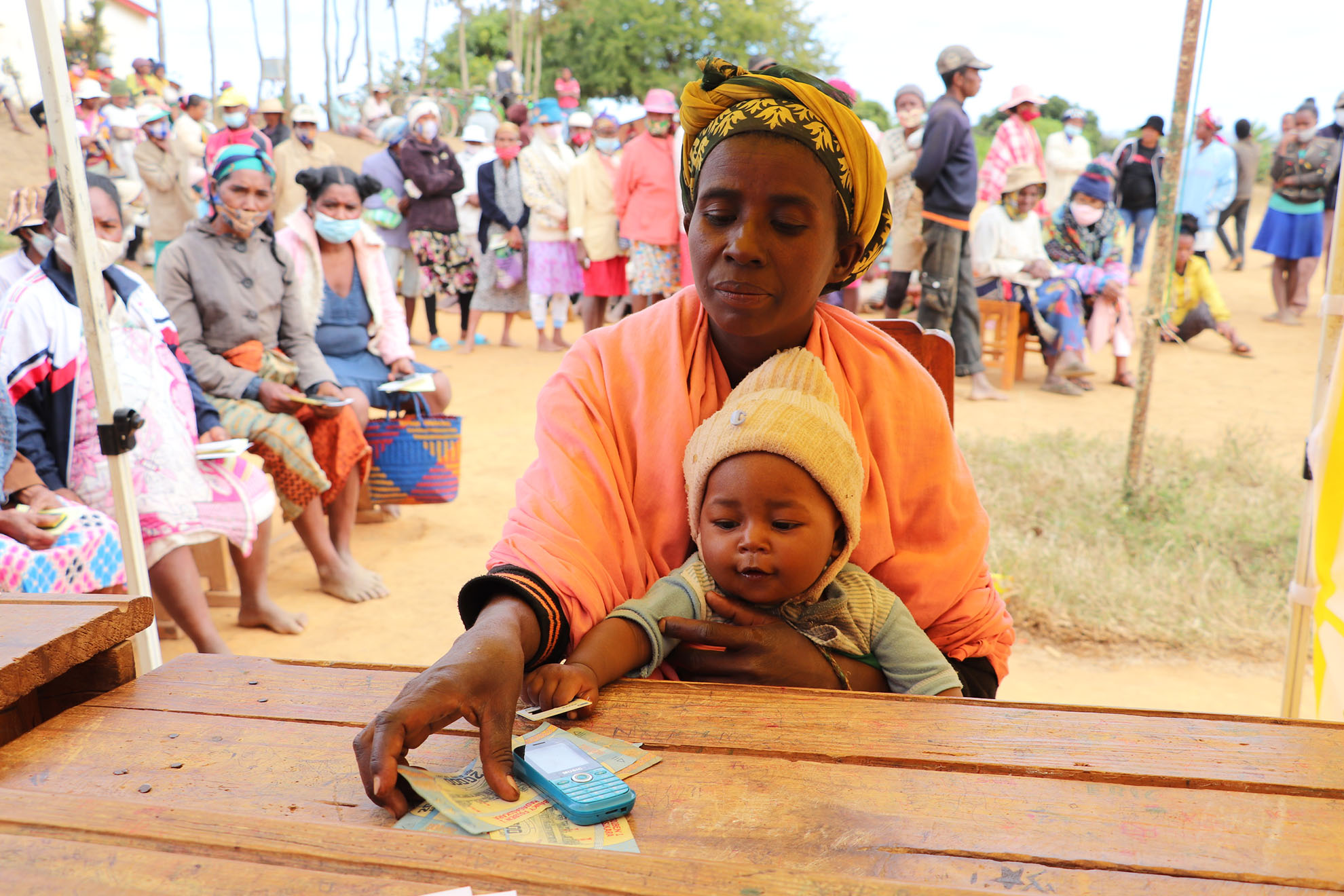 Eine Frau und ihr Baby beim Cash Transfer in Madagaskar. Anticipatory Action bedeutet auch, von Notlagen gefährdete Menschen zu ermöglichen, für sich selbst sorgen zu können.