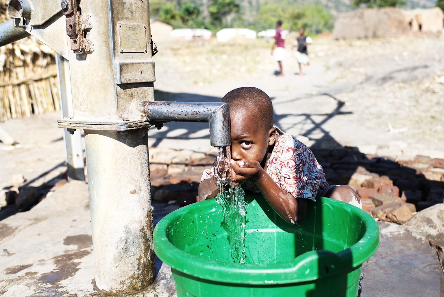 Junge trinkt frisches Wasser aus dem Hahn