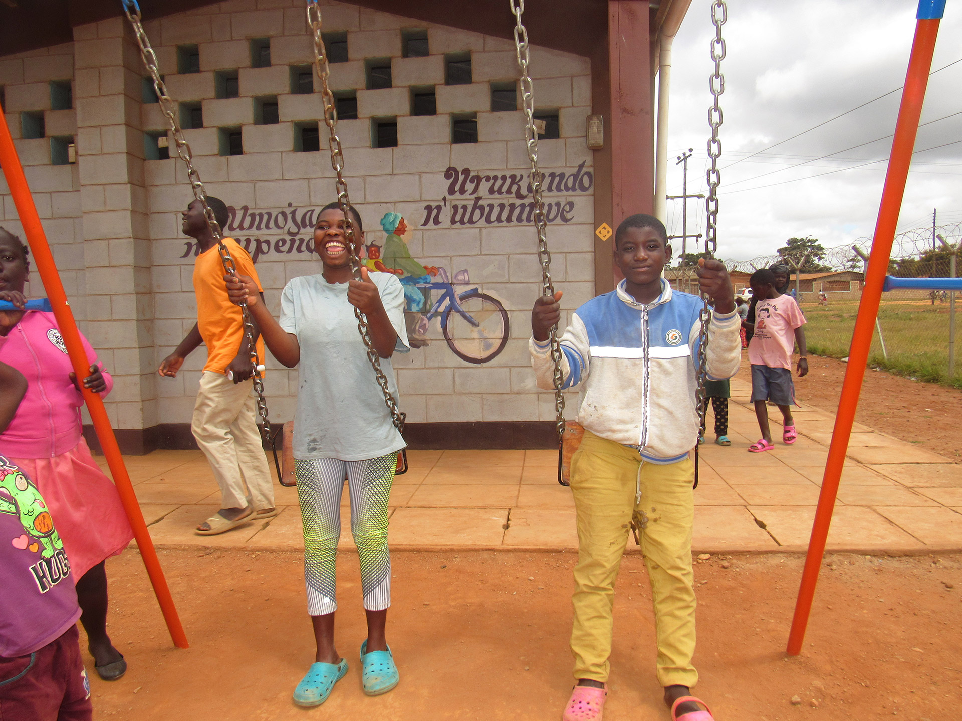 Zwei Kinder spielen auf einer Schaukel, Malawi 2021.