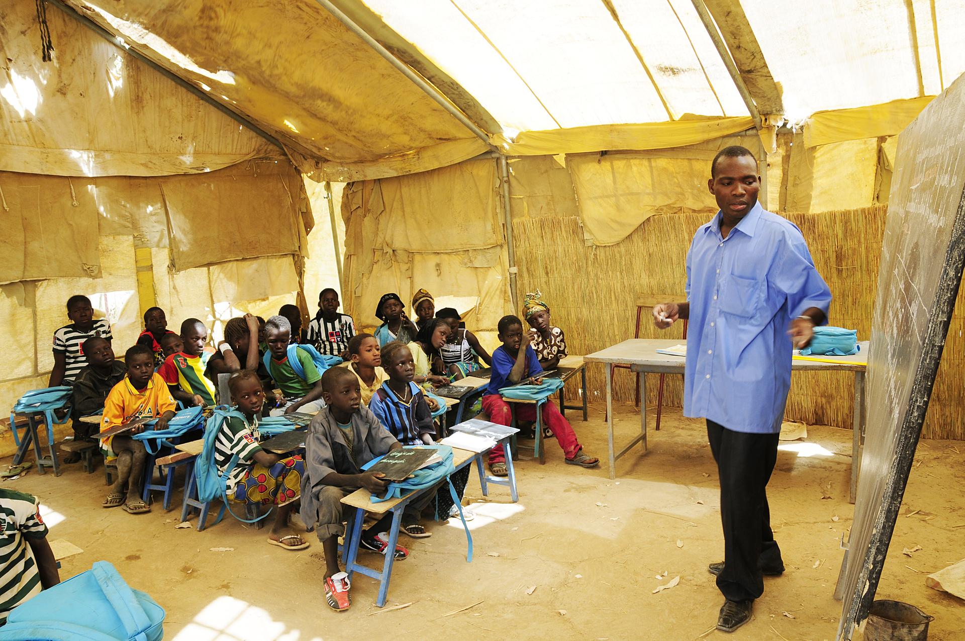 Ein Lehrer erklärt seiner Klasse etwas an der Tafel